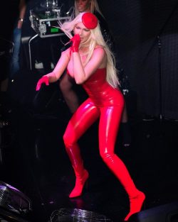 Jelena Karleusa on stage singing in red latex catsuit