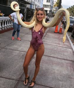 Naomi Woods in swimsuit with giant snake on public street